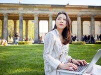日本人が海外でパソコン作業をしているイメージの画像